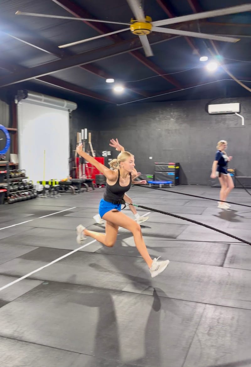 Athlete sprinting with battle ropes at Straub